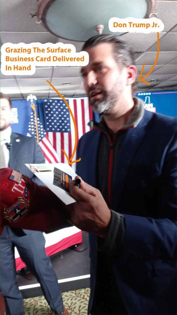 Donald Trump Jr. Holding a Grazing the Surface Business Card